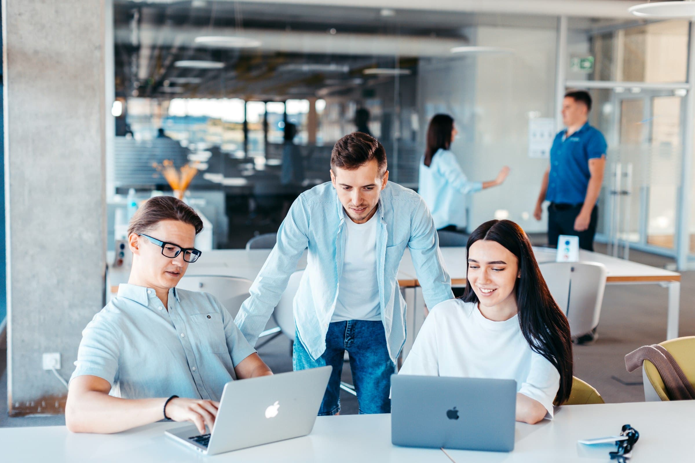 Team arbeitet gemeinsam an Laptops im Büro
